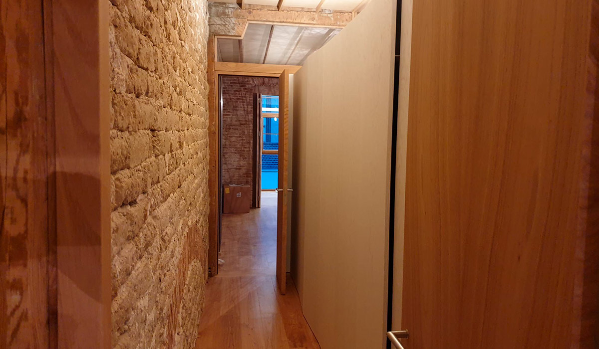 Pasillo de ladrillo y madera del piso diseñado en la Acera Recoletos en Valladolid